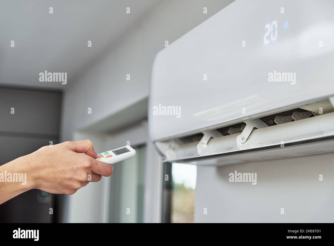 Regolazione manuale della temperatura sul climatizzatore con telecomando,  condizionatore d'aria funzionante per una temperatura confortevole a casa  durante l'estate calda Foto stock - Alamy