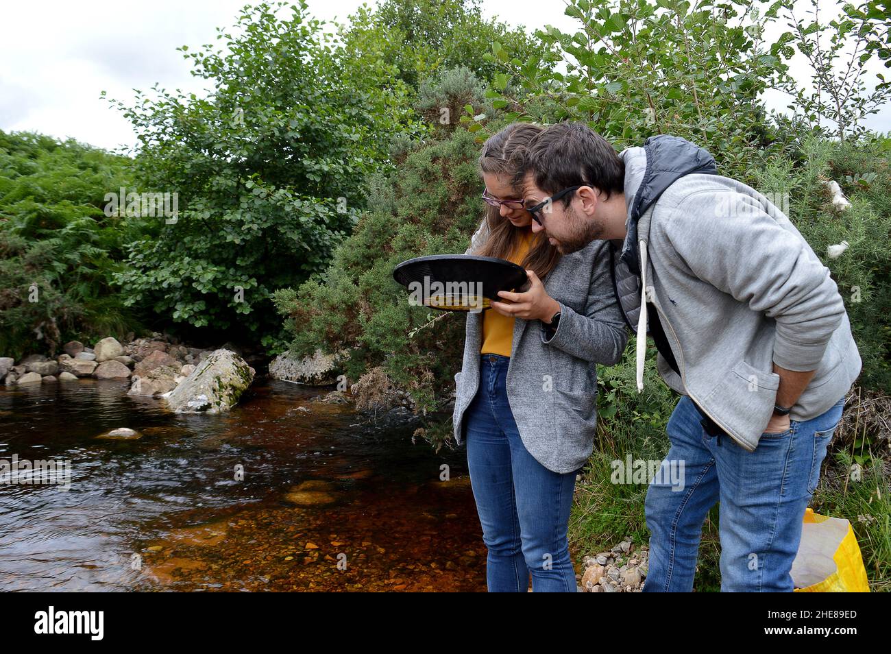 Coppia in panning per l'oro sul Kildonan Burn a vicino Helmsdale, Sutherland, Scozia Foto Stock