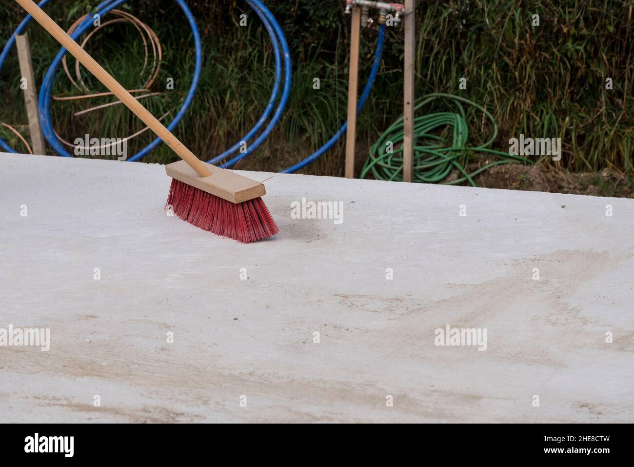 Pulire il sito di costruzione con una spazzatura - spazzare con una spazzatura stradale Foto Stock