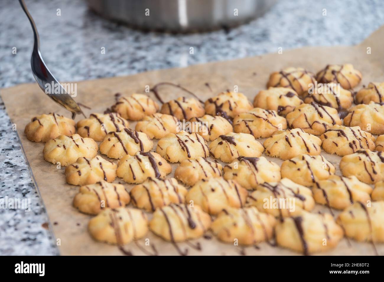 Preparare i biscotti di Natale e decorare con glassa al cioccolato Foto Stock