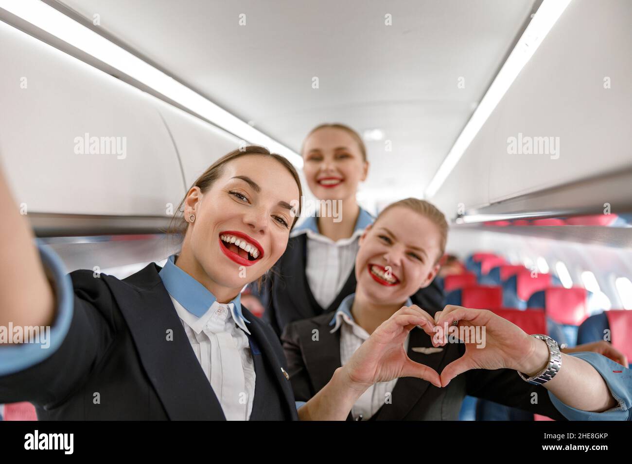 Allegri assistenti di volo che si divertono in aereo Foto Stock