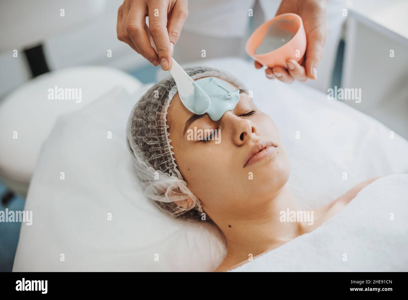 Primo piano ritratto delle mani del cosmetologo applicazione maschera  alginato con spatola sul volto di una donna in salone spa. Trattamento  medico. Trattamento viso Foto stock - Alamy