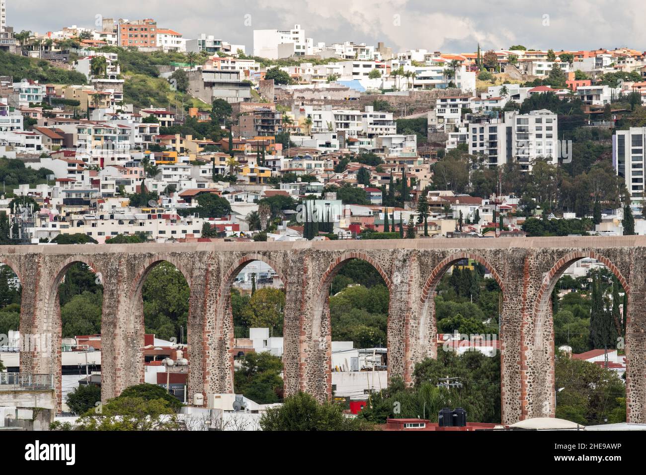 L'antico acquedotto di pietra di Queretaro nella vecchia sezione coloniale con lo skyline di Santiago de Queretaro, Stato Queretaro, Messico. L'acquedotto fu completato nel 1735 ed è il più grande del Messico. Foto Stock