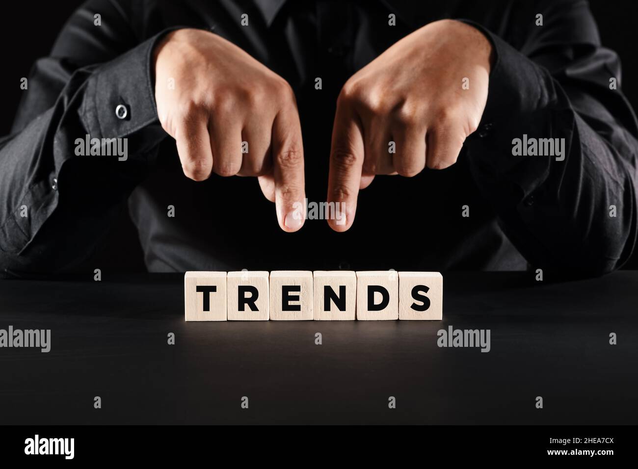 Mani maschili che mostrano i cubi di legno con le tendenze di parola. Nuove tendenze nel mercato commerciale o nel concetto di tecnologia. Foto Stock