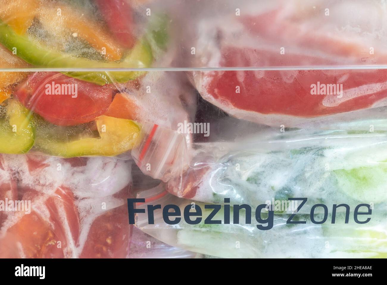Affettato frutti maturi di peperone in sacchetti di cellophane, preparati per il congelamento e la conservazione a lungo termine nel comparto freezer del frigorifero. V. Anteriore Foto Stock