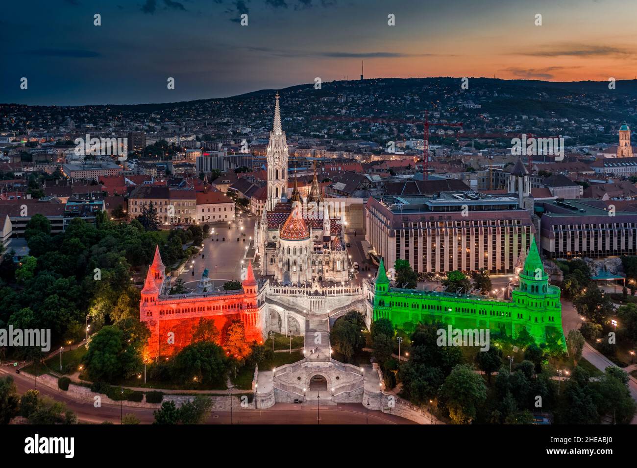 Budapest, Ungheria - veduta aerea il famoso Bastione illuminato del Pescatore (Halaszbastya) e la Chiesa di Mattia illuminate con rosso nazionale, bianco e granello Foto Stock