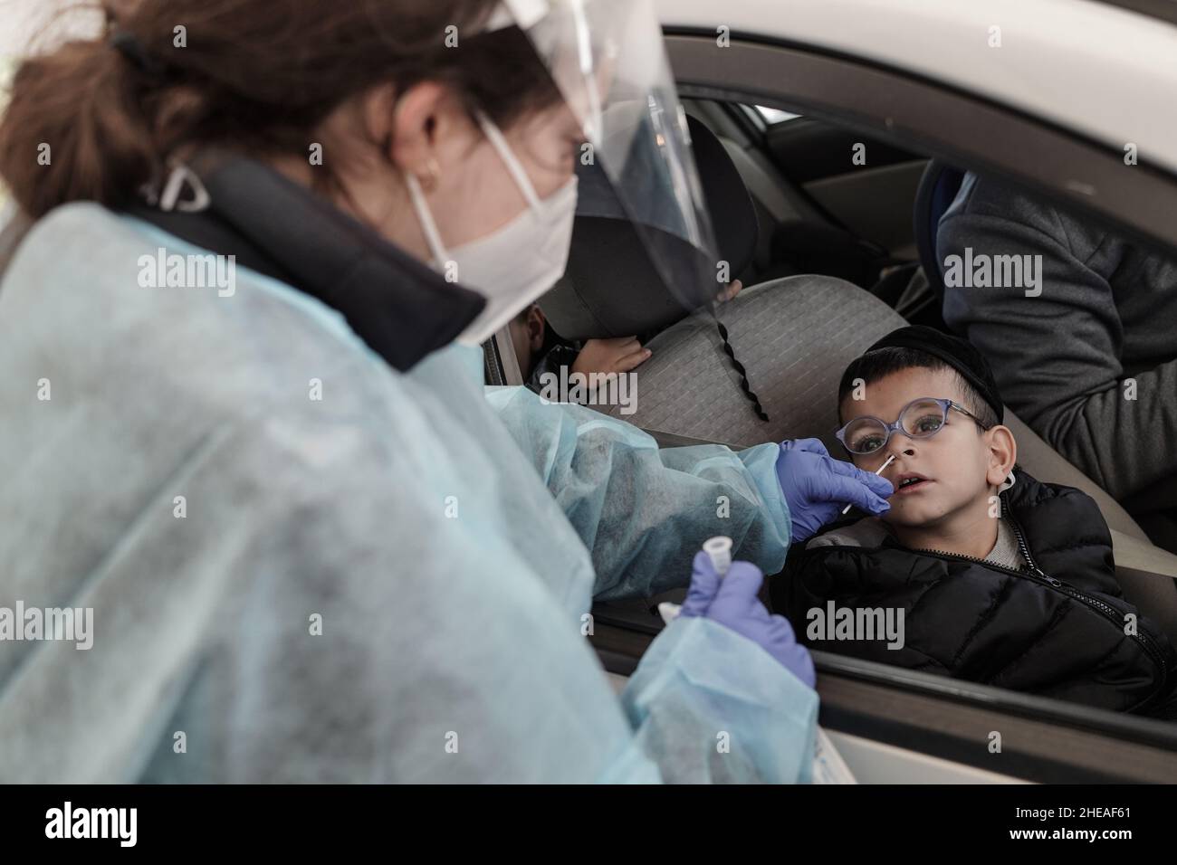 Gerusalemme, Israele. 10th Gennaio 2022. Gli israeliani sono sottoposti a test COVID-19 presso il complesso Ein Yael Drive Thru a Gerusalemme, mentre Israele si trova di fronte a un aumento dell'infezione da Coronavirus, molto probabilmente a causa della variante Omicron. Magen David Adom, il principale SME di Israele, conduce test PCR per gli anziani e test antigenici per tutti gli altri, poiché una carenza di kit di test PCR minaccia il prossimo futuro. Sebbene i test sugli antigeni si siano rivelati significativamente imprecisi, fornendo risultati SIA FALSI POSITIVI che FALSI NEGATIVI, alcuni dei sistemi economici e educativi del paese si basano su test frequenti per coloro che non sono vaccinati. Rosso Foto Stock