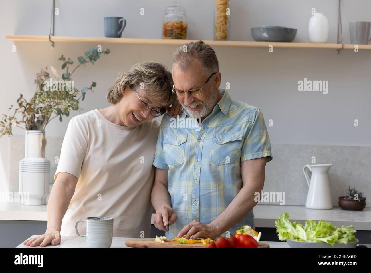 Gioiosa coppia di famiglia di mezza età che cucinano in cucina moderna. Foto Stock