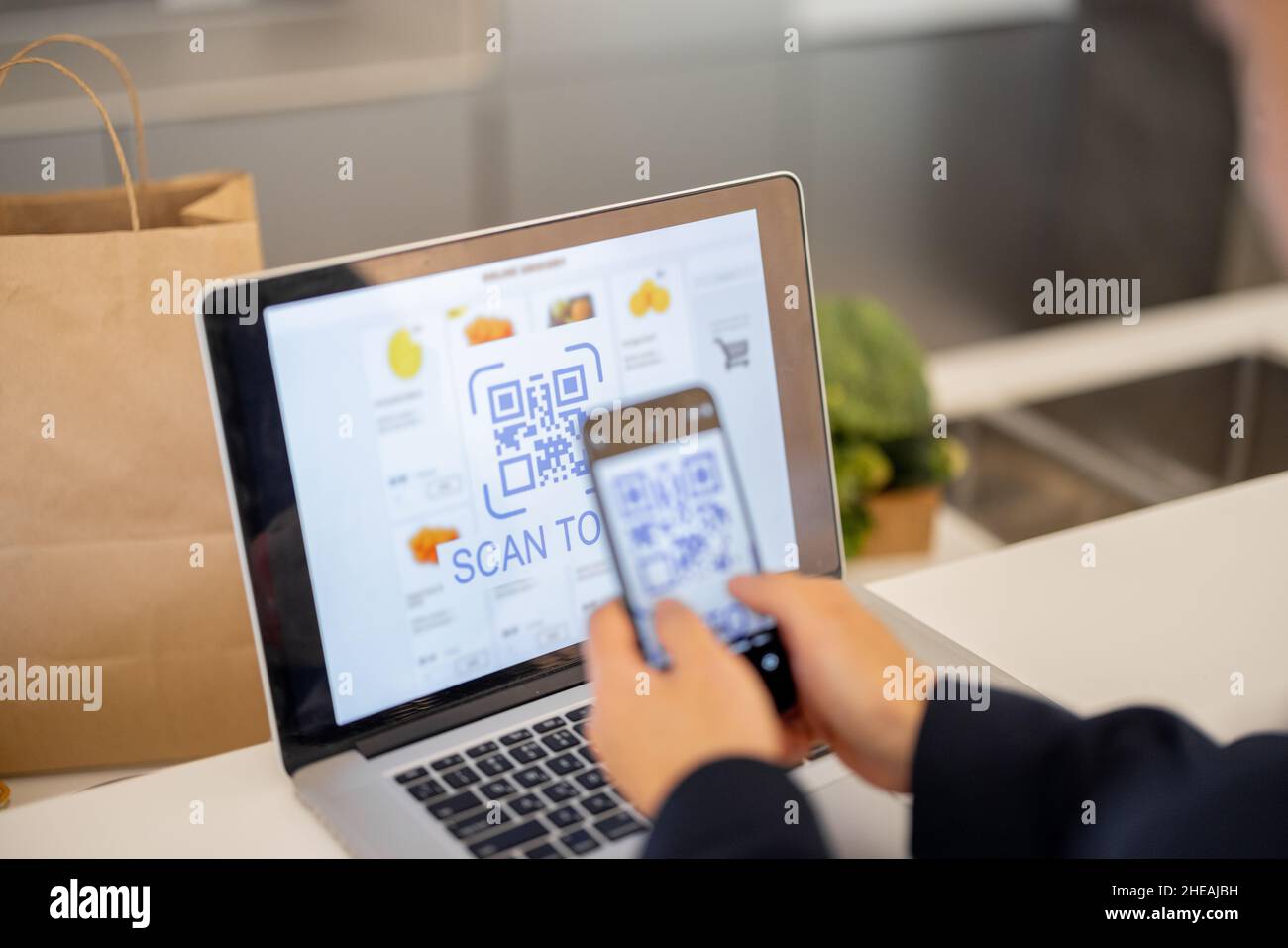Uomo che utilizza lo smartphone per il pagamento nel negozio online Foto Stock