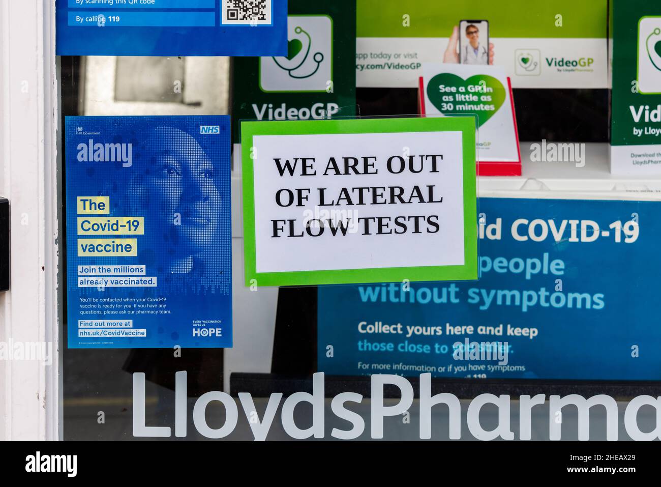 Firma 'Siamo fuori dei test di flusso laterale' e Covid-19 informazioni segni nella finestra della farmacia Lloyds in High Street, Winchester, Hampshire, Inghilterra Foto Stock