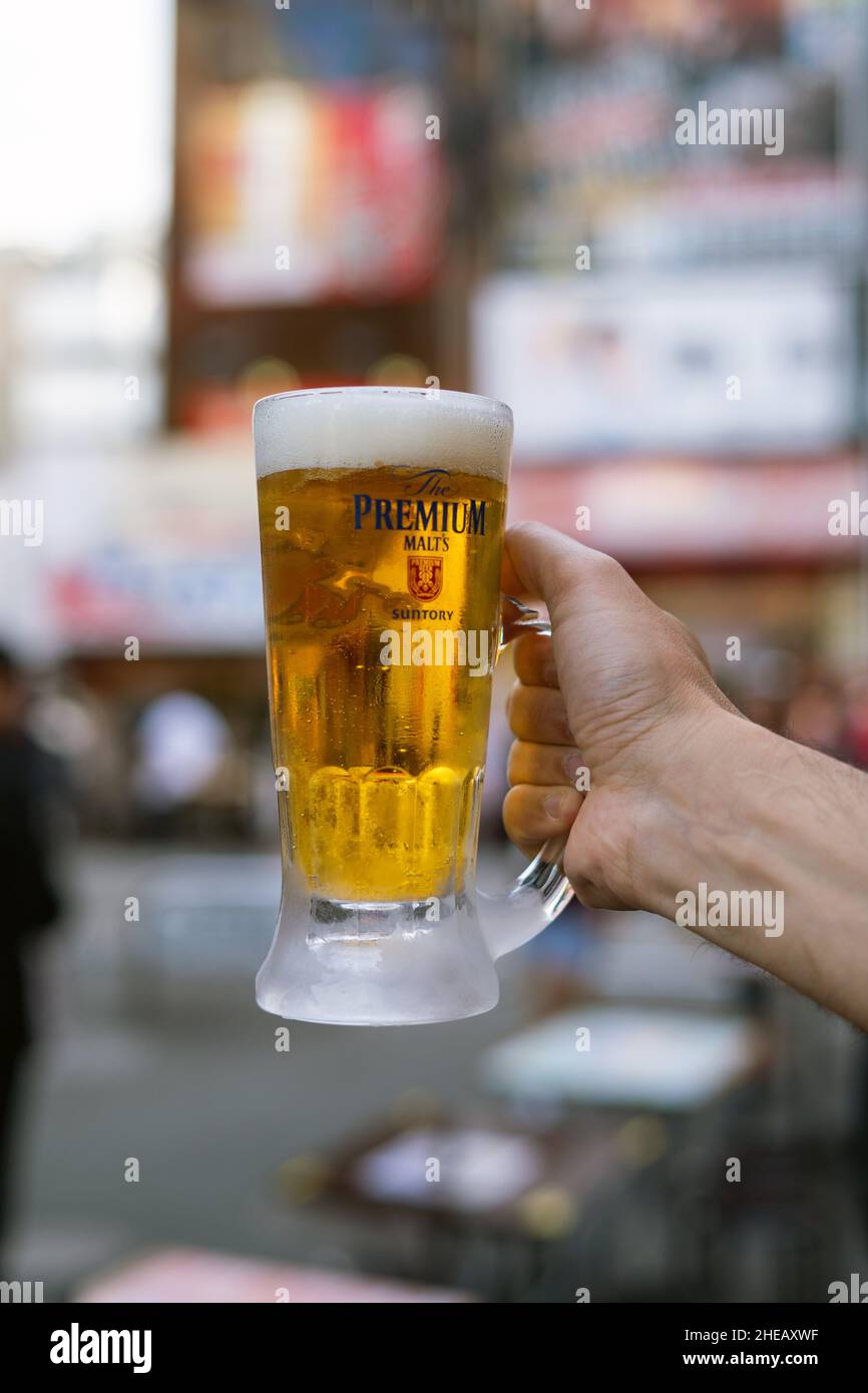 Dettaglio della mano di un uomo che tiene una pinta di birra Foto Stock