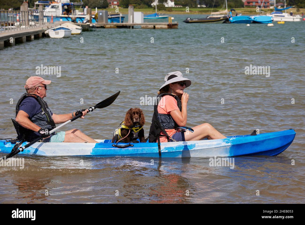 Coppia e il loro cane visto prepararsi per un viaggio con la canoa a West Itchenor. Foto Stock