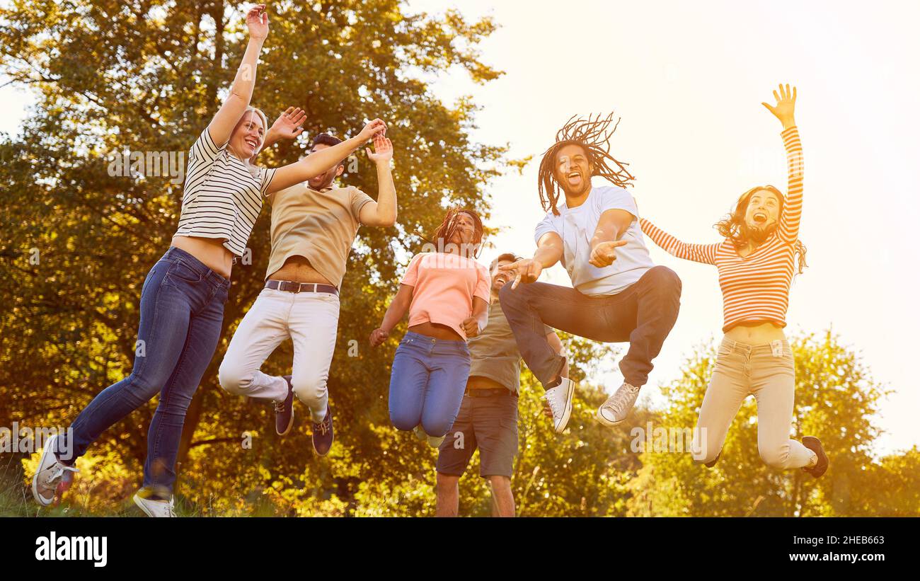 Un gruppo felice di amici si diverte a saltare in natura in estate Foto Stock