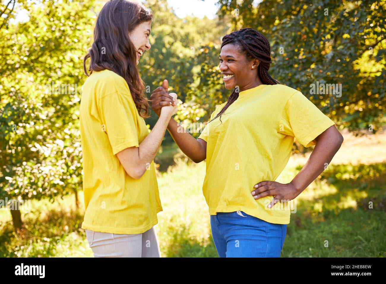 Due amiche a un evento sportivo durante la stretta di mano per lavoro di squadra e saluto Foto Stock