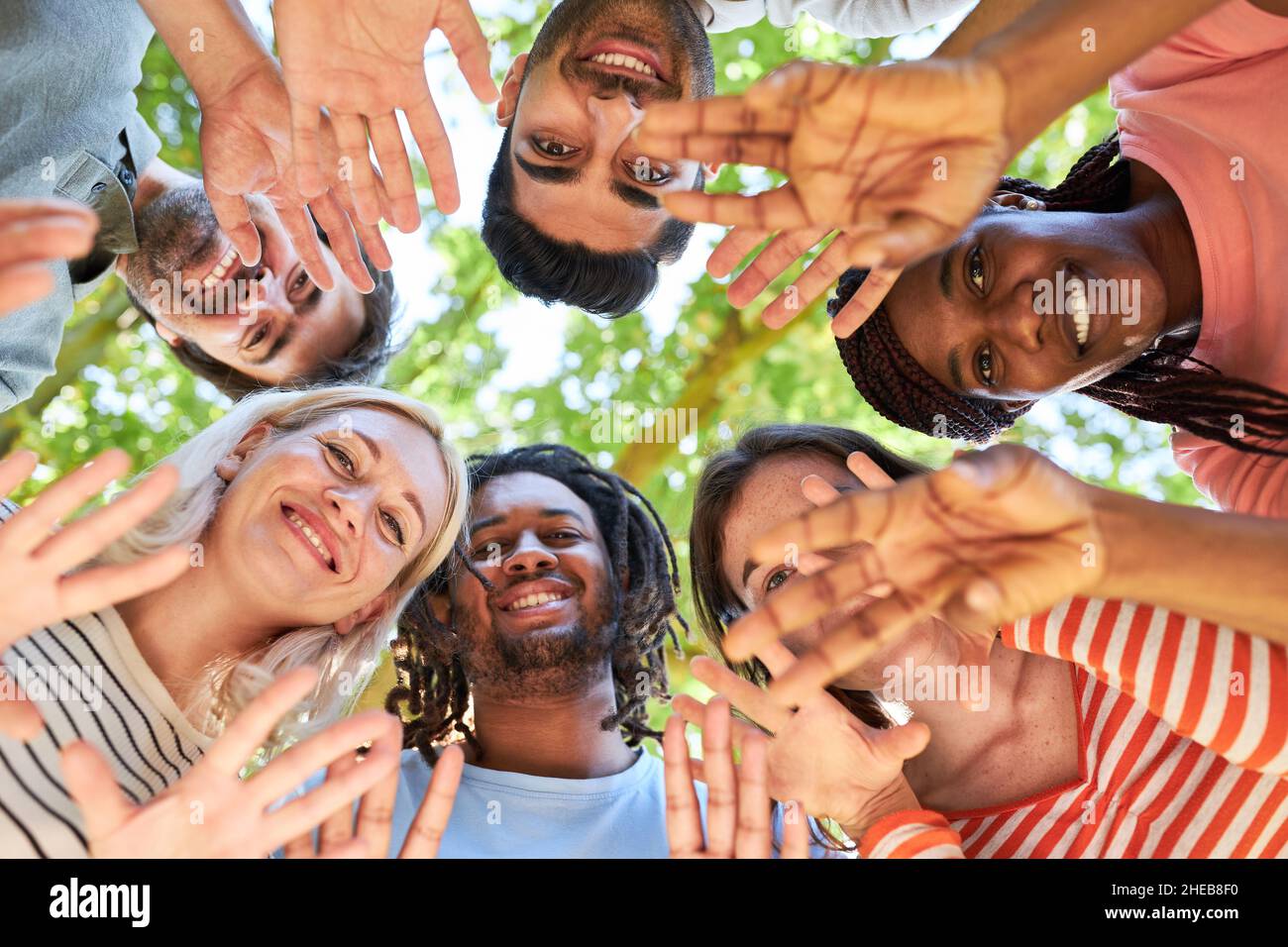 Gruppo di giovani in cerchio che sventolano in un laboratorio di team building in natura Foto Stock