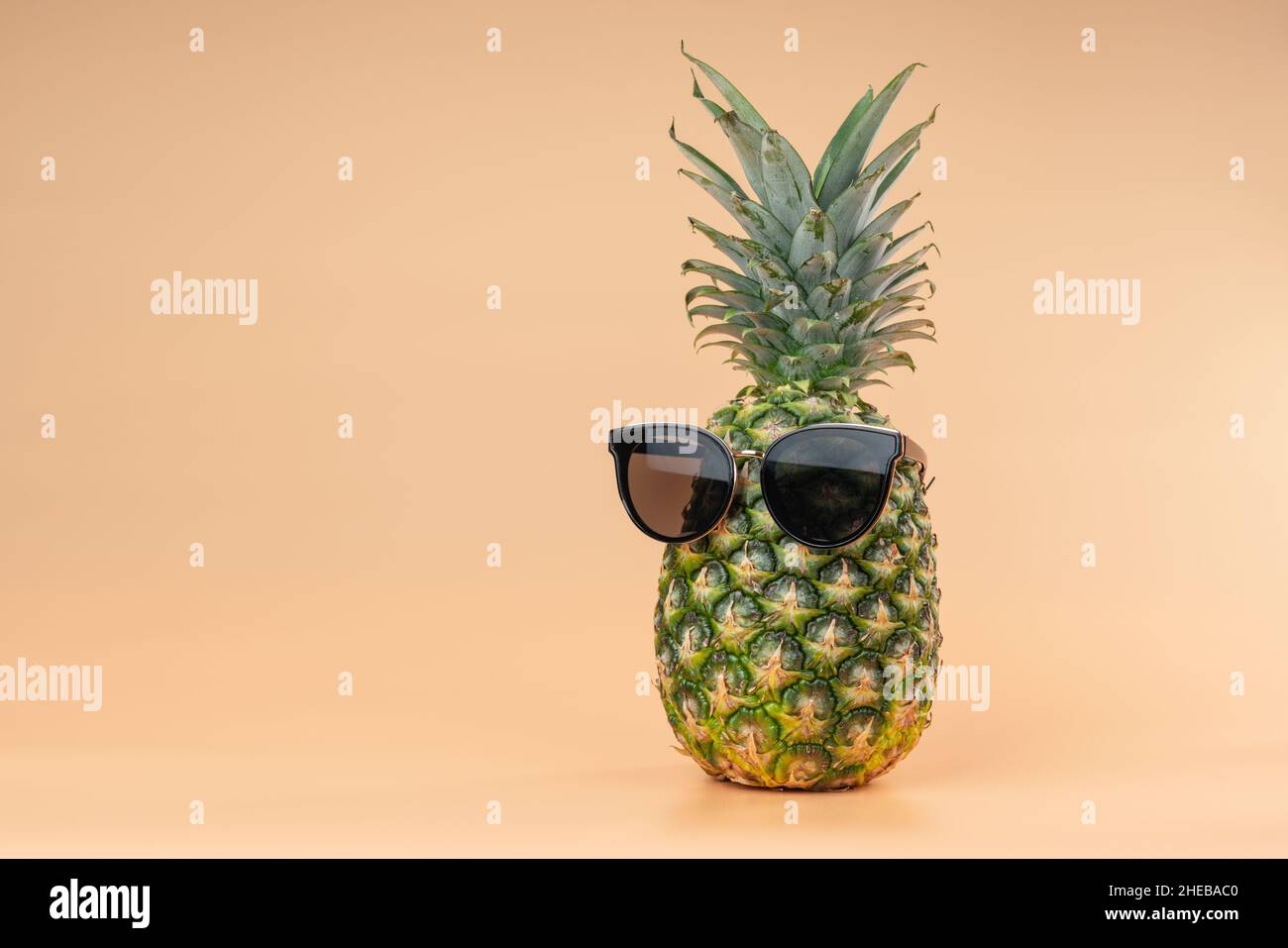Interpretazione della frutta di ananas nell'immagine umana nel concetto di turismo e vacanze occhiali da sole. Spazio di copia su sfondo giallo Foto Stock