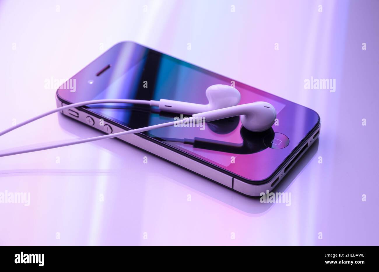 Smartphone Apple iPhone 4S con auricolari e colorati effetti di luce viola,  stile di vita o concetto di comunicazione Foto stock - Alamy