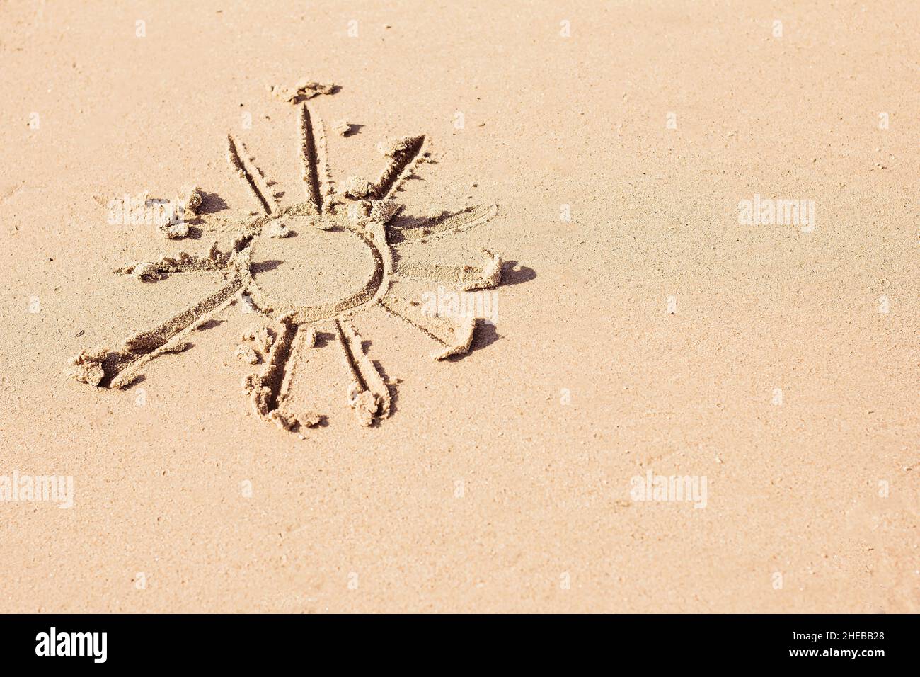 Il sole è dipinto sulla sabbia, riposo ed estate, stagione calda, stagione balneare, protezione solare Foto Stock