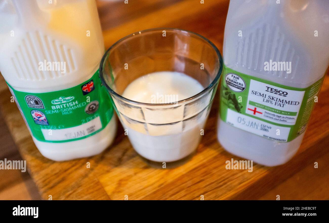 Scatole di latte da supermercato e un bicchiere di latte parzialmente scremato con uso in date che mostrano la fotografia britannica scattata da Simon Dack Foto Stock