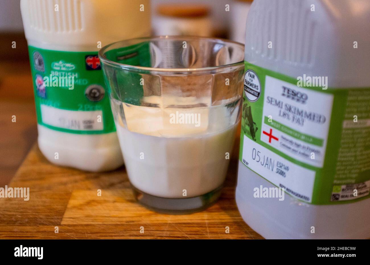 Scatole di latte da supermercato e un bicchiere di latte parzialmente scremato con uso in date che mostrano la fotografia britannica scattata da Simon Dack Foto Stock