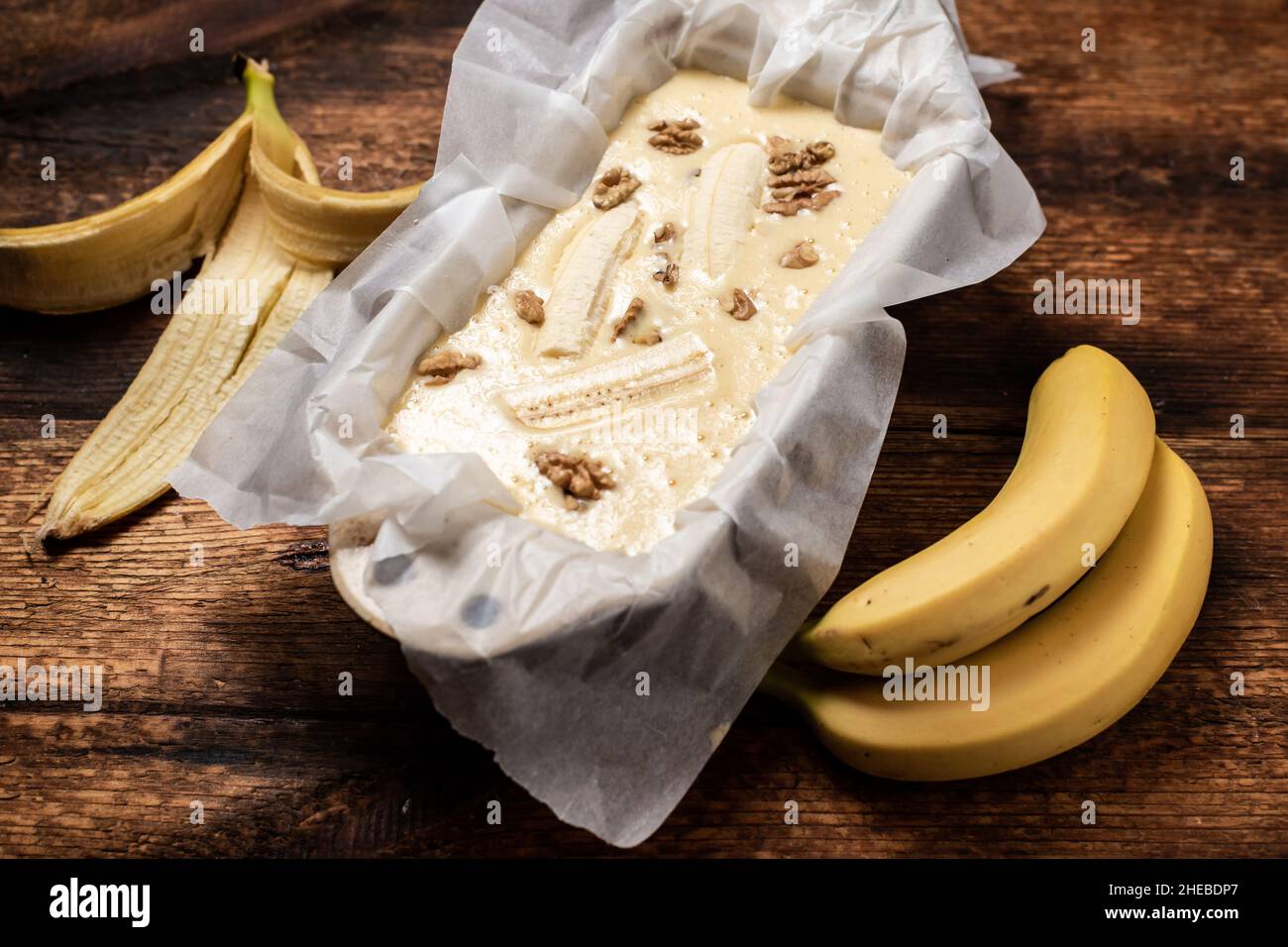 Pane alla banana. Cucina. Cibo vegetariano. Cupcake con banane e noci su sfondo di legno. Foto Stock