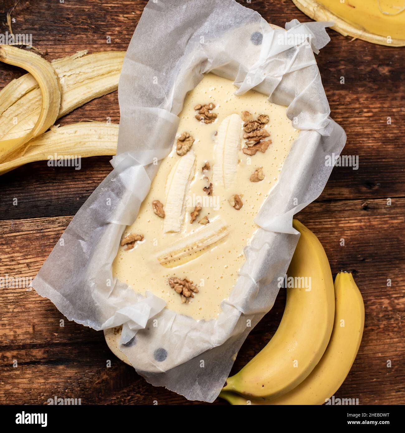 Pane alla banana. Cucina. Cibo vegetariano. Cupcake con banane e noci su sfondo di legno. Foto Stock