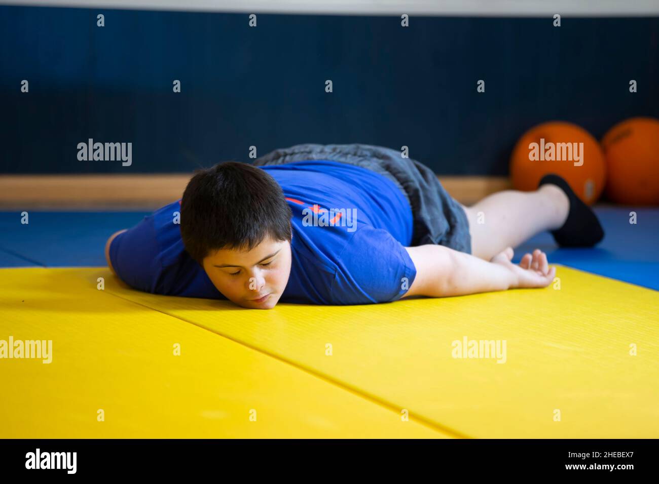 Bielorussia, la città di Gomel, 23 giugno 2021. Judo club. Un bambino con sindrome di Down si trova su un tappetino in palestra. Foto Stock