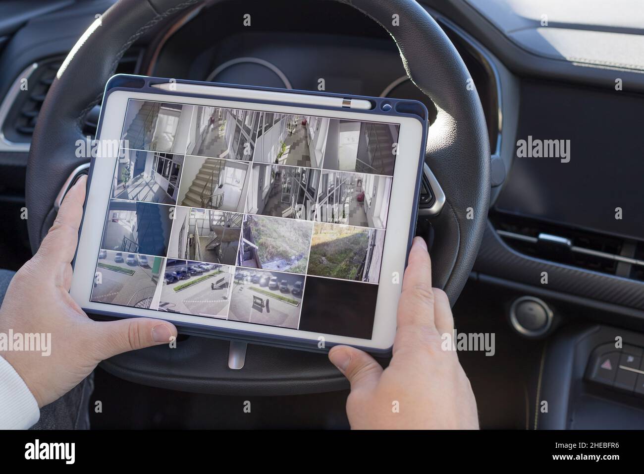 Uomo seduto in auto e che guarda le telecamere di monitoraggio Foto Stock