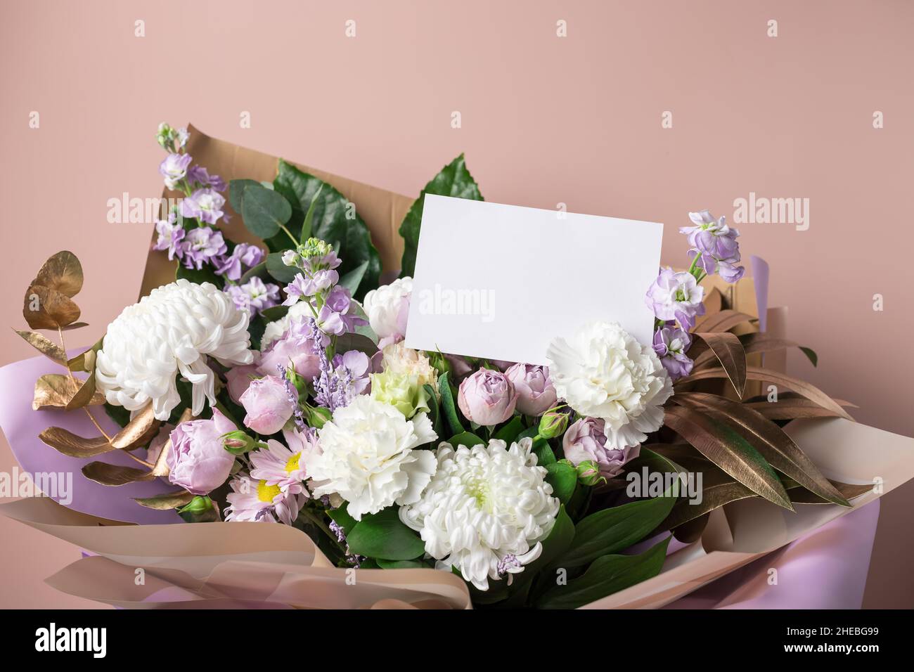 bouquet di fiori misti su sfondo colorato con carta bianca Foto Stock