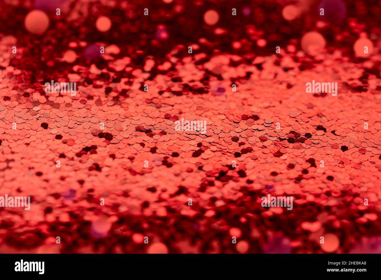 Sfondo rosso sequin bokeh non focalizzato per composizioni di Natale o storie d'amore di San Valentino. Foto Stock