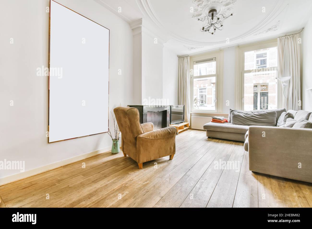 Incredibile soggiorno con divano grigio e poltrona marrone Foto Stock