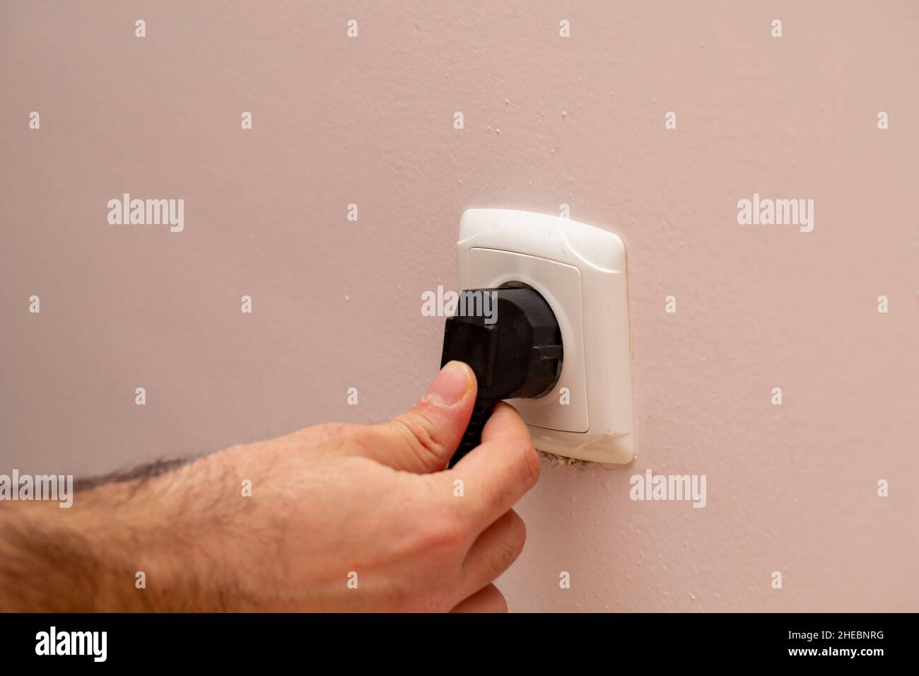 La mano della persona che inserisce il tappo Foto Stock