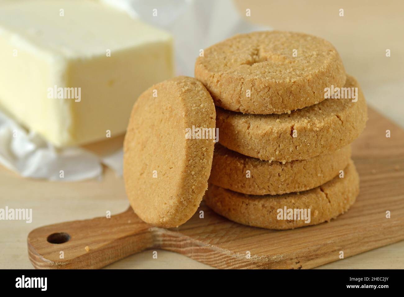 Biscotti tradizionali di Prostone su tagliere di legno e un bastone di burro - dessert tipico della Valchiavenna e della Valtellina Foto Stock