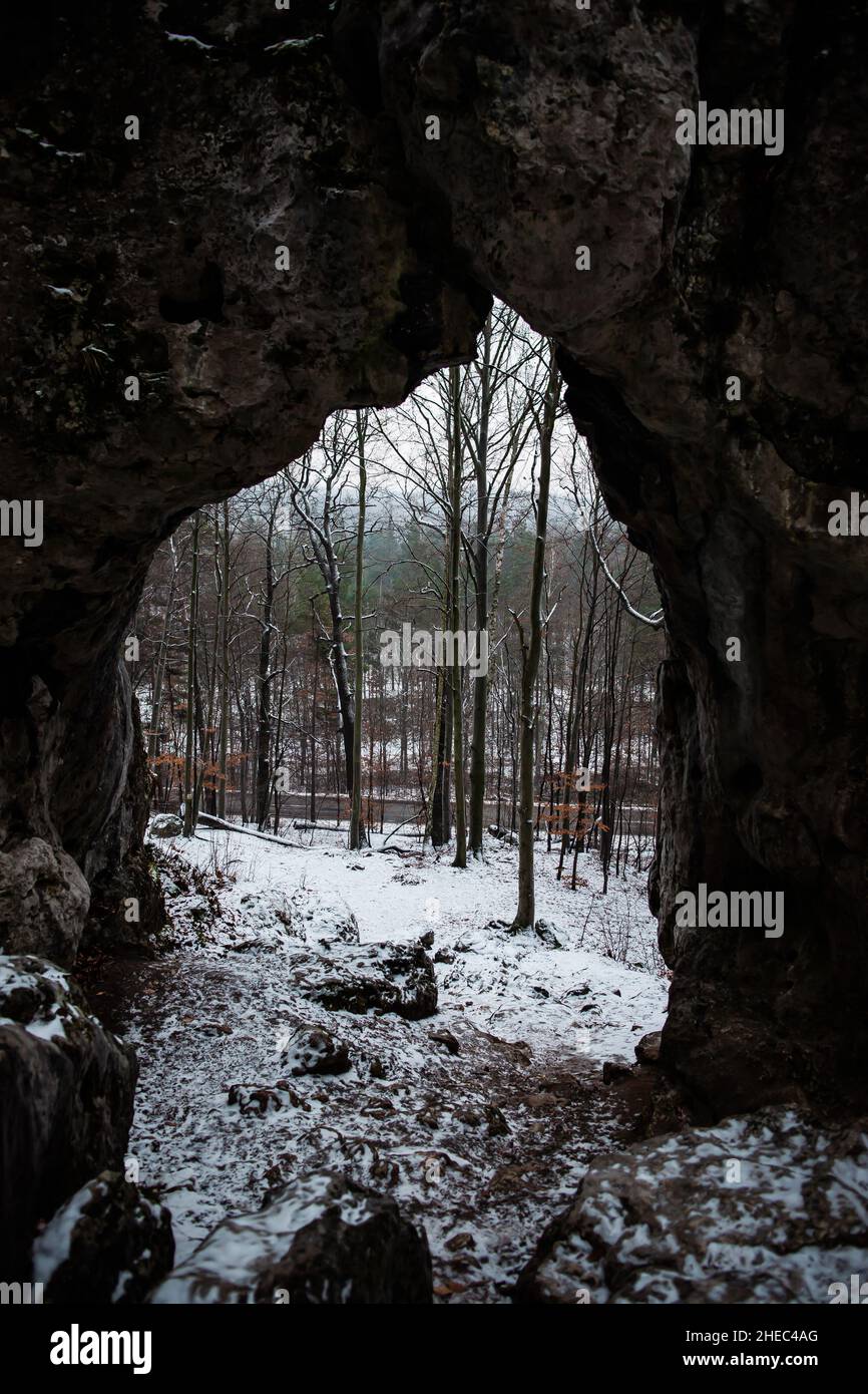 Vista dall'interno della grotta con bellissimo paesaggio forestale invernale | Foresta in inverno vista dall'alto dalla grotta in cima alla collina Foto Stock