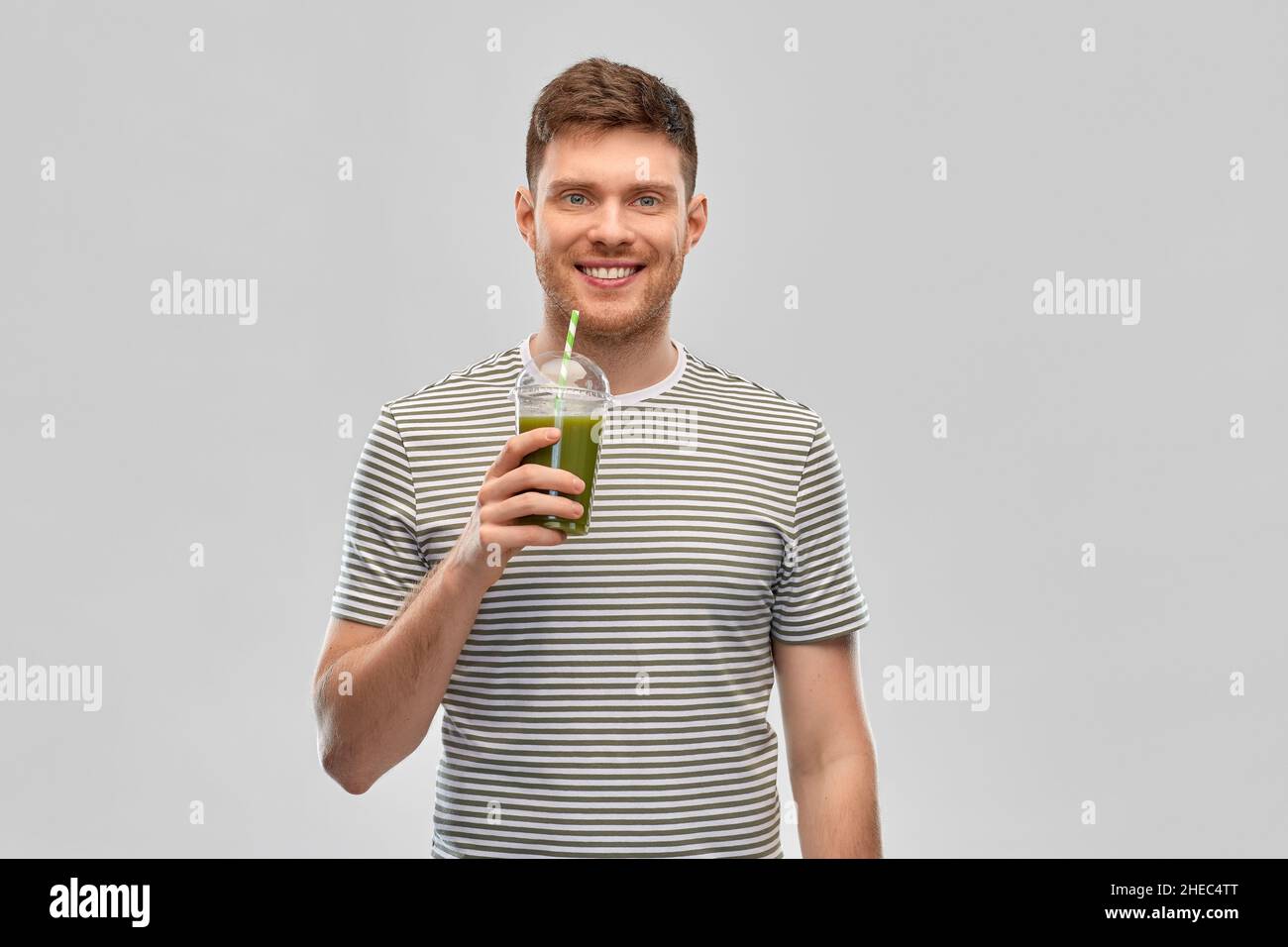 uomo che beve frullato verde da tazza usa e getta Foto Stock