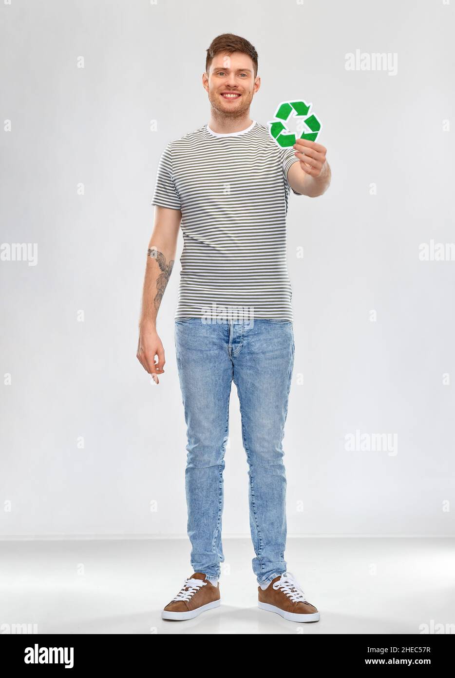 sorridente giovane uomo con cartello verde di riciclaggio Foto Stock