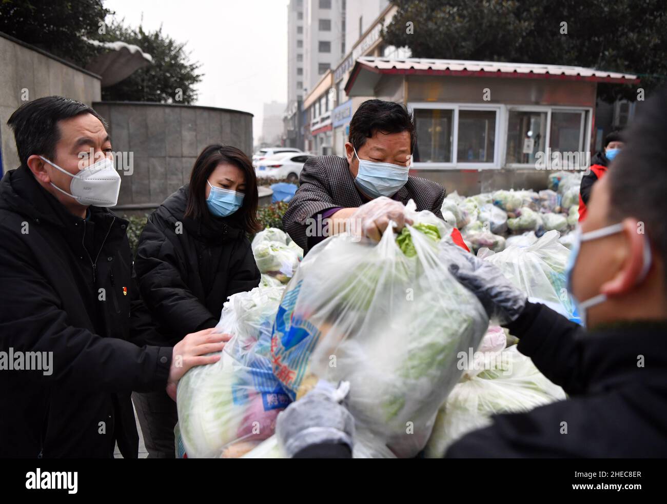 (220110) -- ZHENGZHOU, 10 gennaio 2022 (Xinhua) -- i volontari caricano le verdure per i residenti sotto quarantena domestica su un camion nella città di Yuzhou, provincia centrale di Henan della Cina, 10 gennaio 2022. Henan domenica ha riferito 60 nuovi casi di COVID-19 trasmessi localmente, la Commissione sanitaria nazionale ha detto nella sua relazione quotidiana il lunedì. (Xinhua/li Jianan) Foto Stock