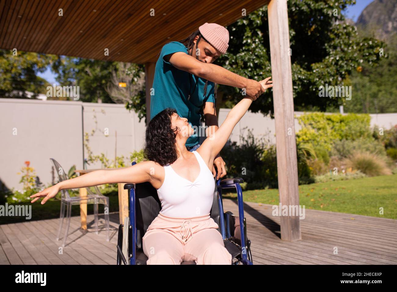 Donna afroamericana disabile su una sedia a rotelle che balla con suo marito all'aperto Foto Stock