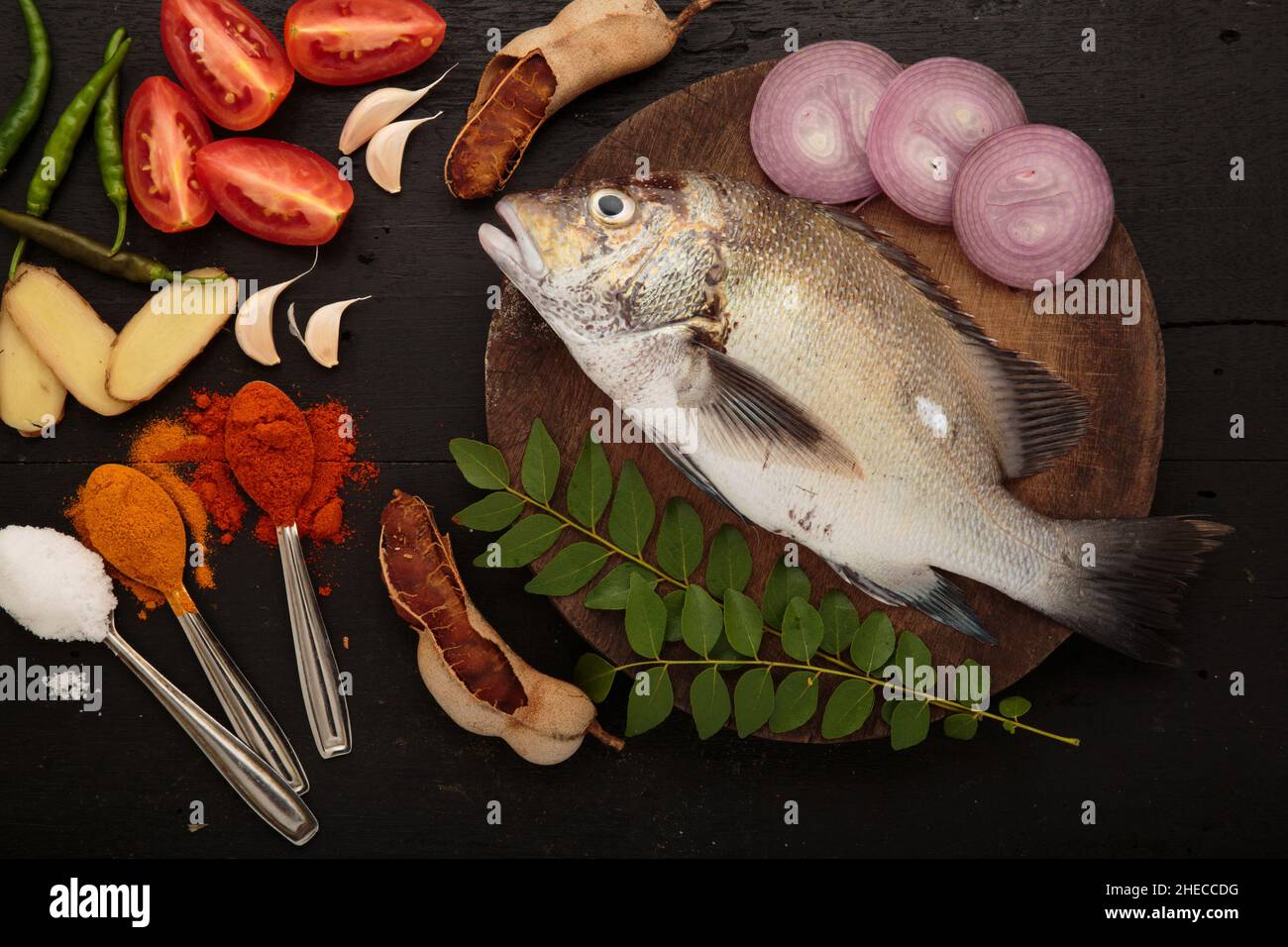 Pesce fresco crudo e ingredienti alimentari, cucina tradizionale di curry di pesce in stile Kerala Foto Stock