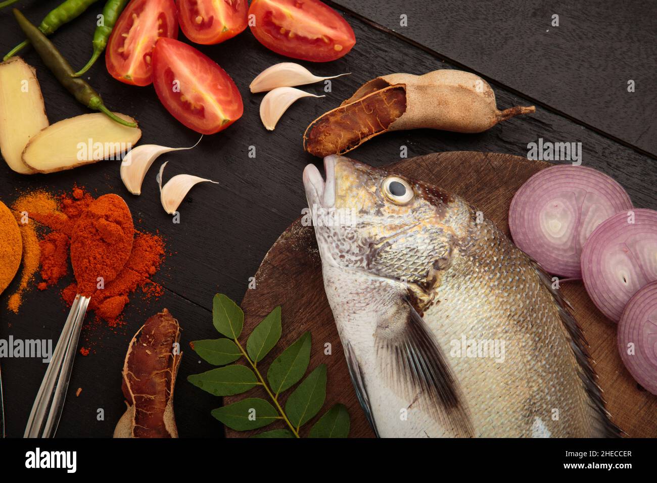 Pesce fresco crudo e ingredienti alimentari, cucina tradizionale di curry di pesce in stile Kerala Foto Stock