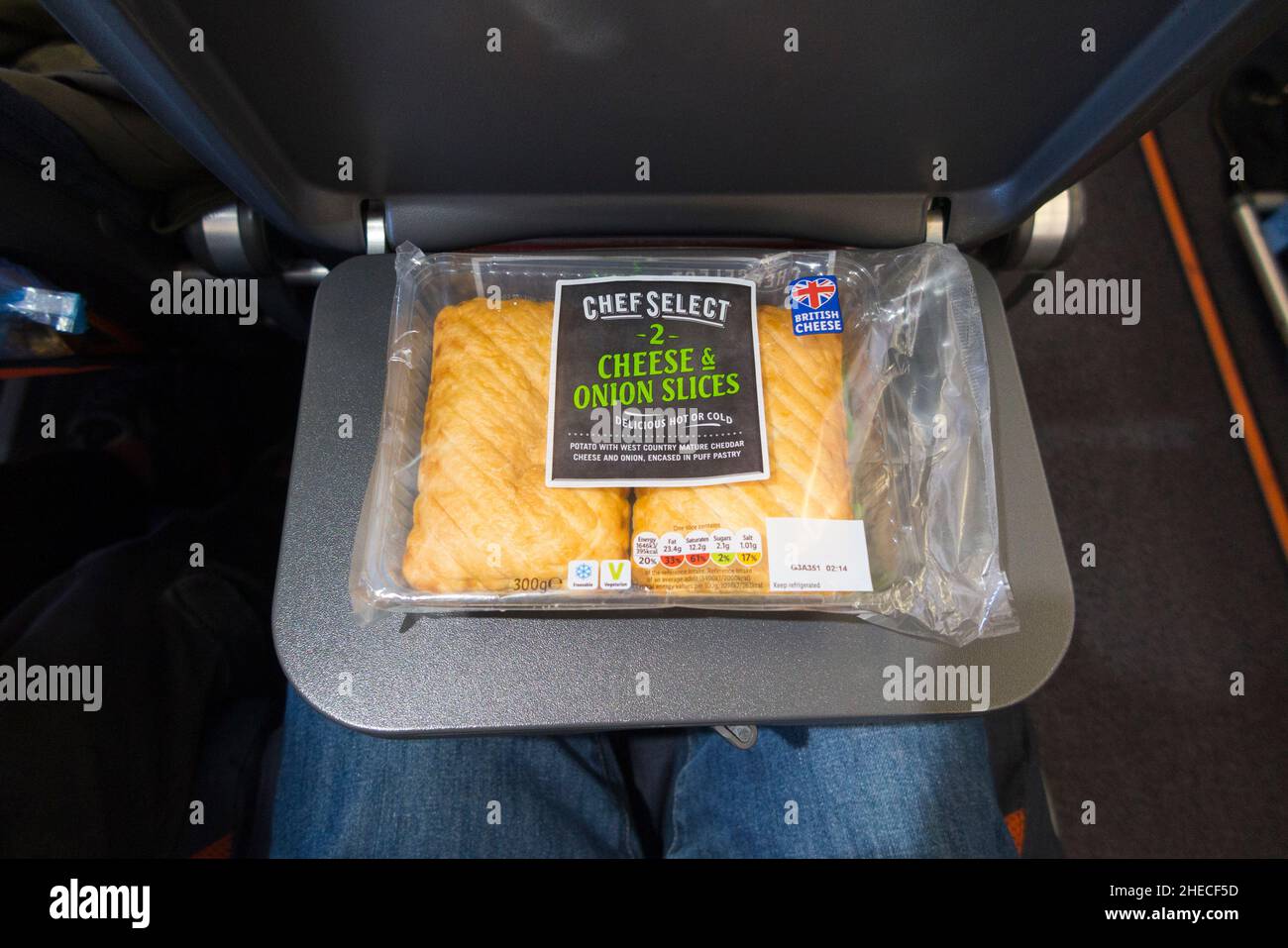 Pasta di formaggio e cipolla, pastie / ripieno di cibo con molta energia, su un tavolo da seduta vassoio, su un aereo Airbus A320 o A319. Parte di un pranzo al sacco per un passeggero che ha preso il cibo snack a bordo del volo Easyjet per parte di un pasto self-catering. (128) Foto Stock