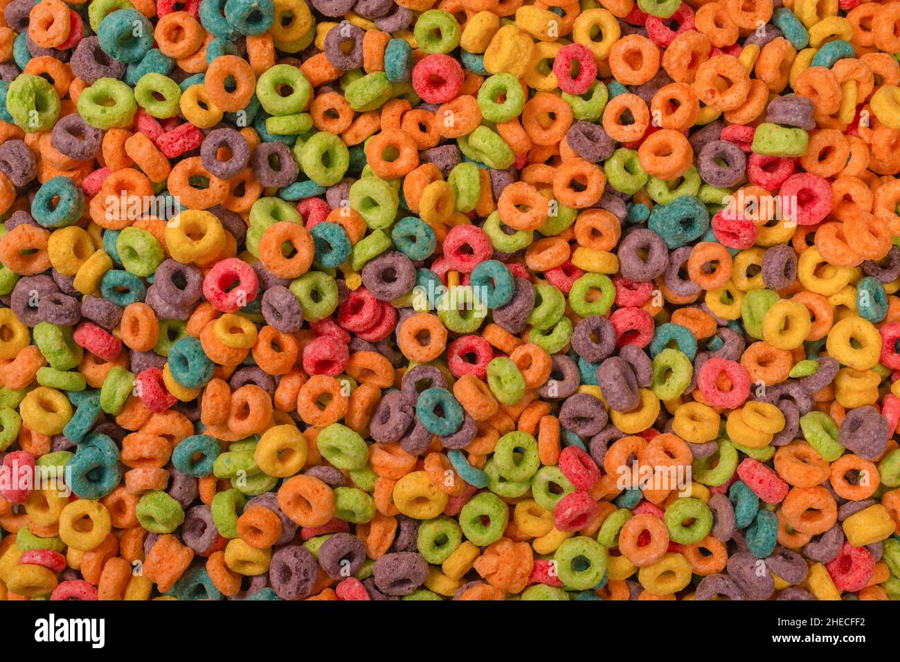 Dolci fiocchi multicolore, anelli di cereali come sfondo. Foto Stock