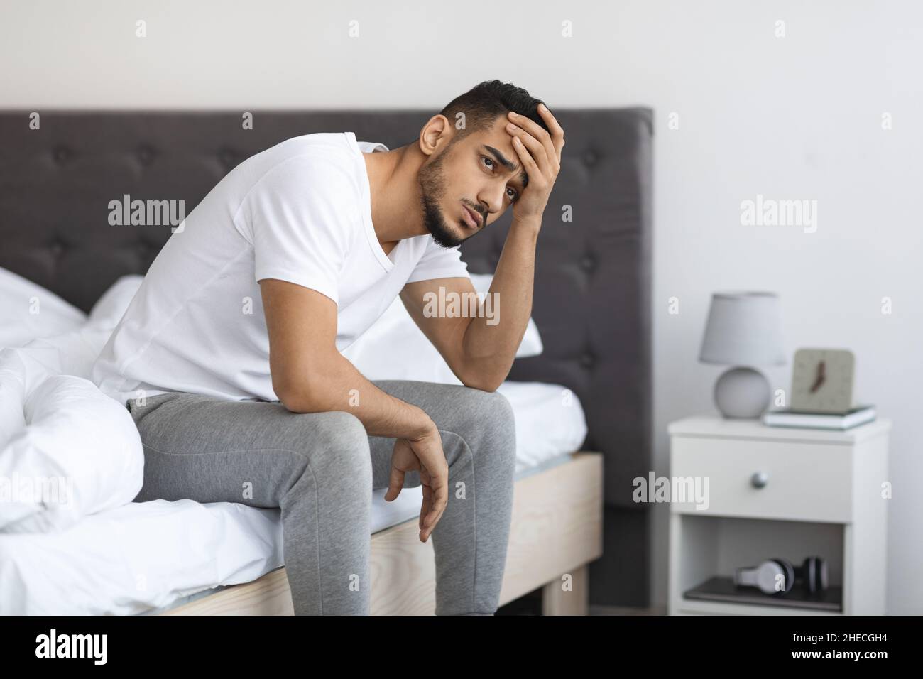 Concetto di apatia. Ritratto di giovane depresso Medio Oriente uomo seduto sul letto Foto Stock