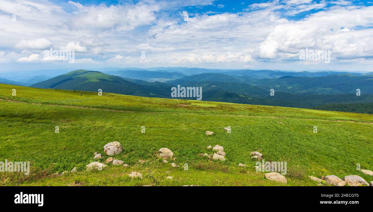splendida vista sul verde paesaggio montano. soleggiato paesaggio naturale all'aperto in estate. pietre sulla collina erbosa. nuvole sopra crinale all'orizzonte nel di Foto Stock