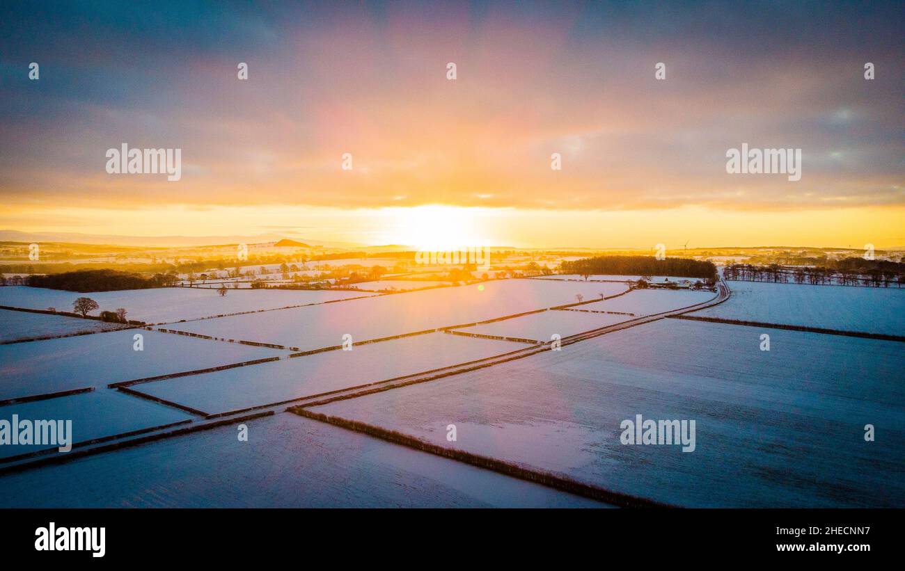 Tramonto invernale su campi innevati Foto Stock