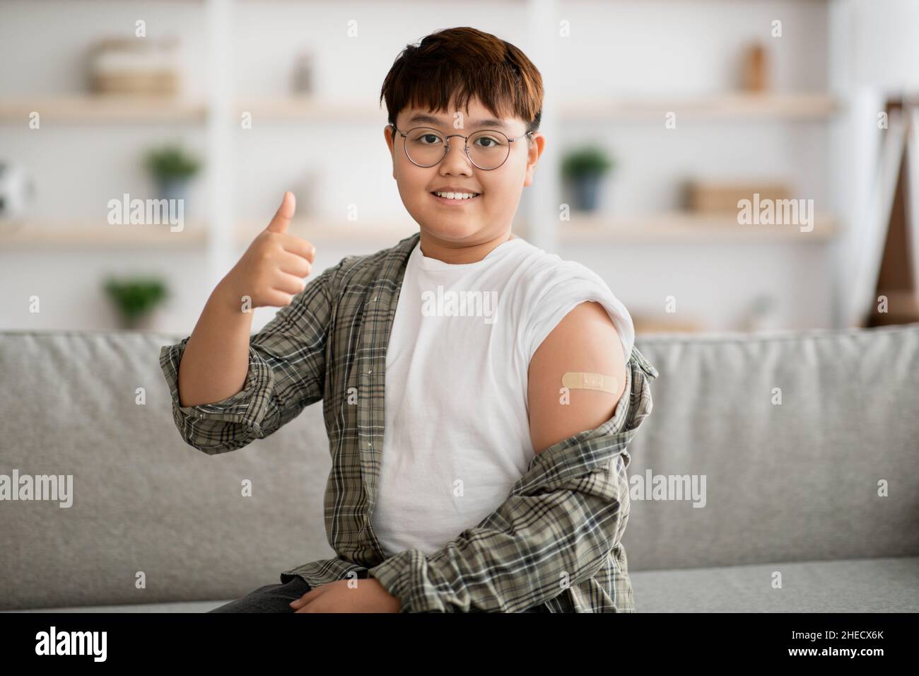 Il bambino coreano è stato vaccinato, mostrando un nastro adesivo sulla spalla Foto Stock