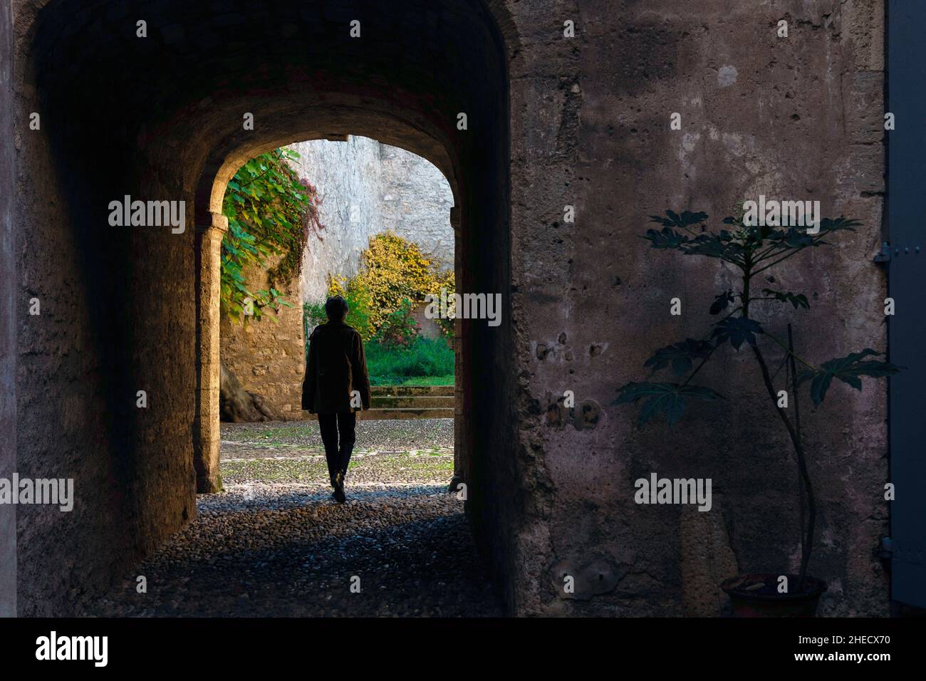 Francia, Herault, Pezenas, silhouette di una persona sotto un portico di un edificio storico Foto Stock