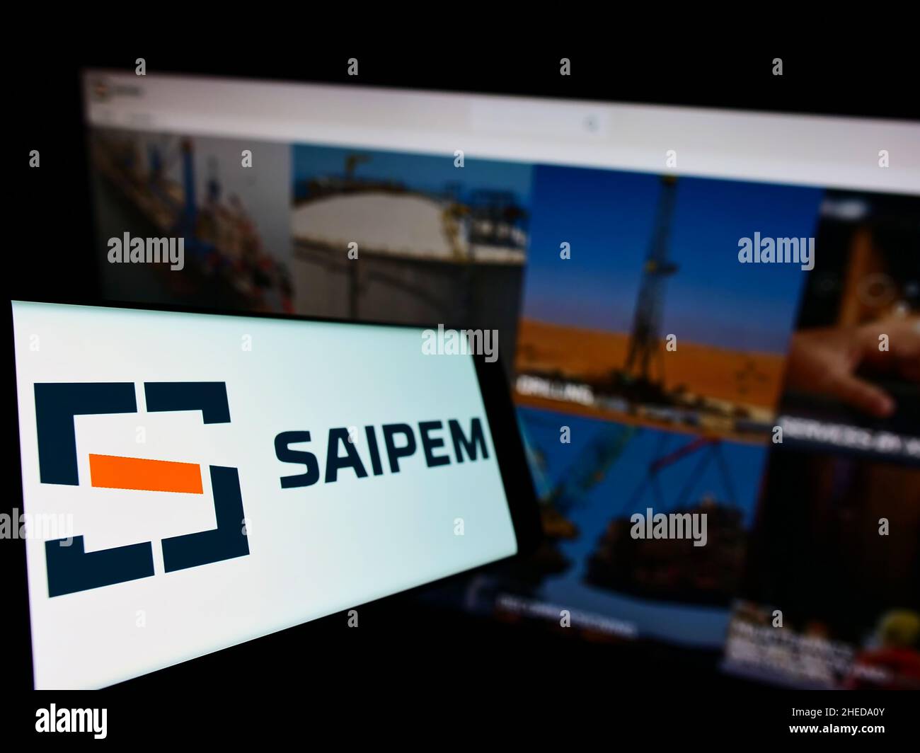 Smartphone con logo della società italiana Saipem S.p.A. di servizi petroliferi sullo schermo di fronte al sito web aziendale. Mettere a fuoco sulla sinistra del display del telefono. Foto Stock