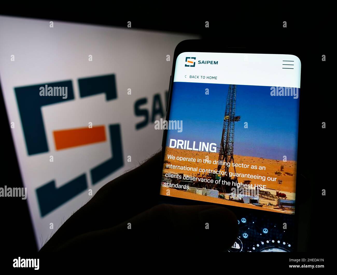 Persona che detiene il cellulare con il sito web della società italiana Saipem S.p.A. di servizi petroliferi su schermo con logo. Concentrarsi sul centro del display del telefono. Foto Stock