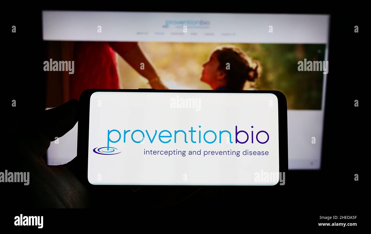 Persona che tiene il cellulare con il logo della società farmaceutica americana Provention Bio Inc. Sullo schermo di fronte alla pagina web. Mettere a fuoco sul display del telefono. Foto Stock
